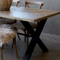 Teilansicht der Tischplatte mit Fischgrätenmuster aus Kiefer und schwarzem Eisenständer