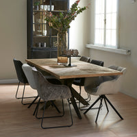 Esszimmer mit einem Esstisch aus recyceltem Eichenholz und gekreuztem Eisengestell.