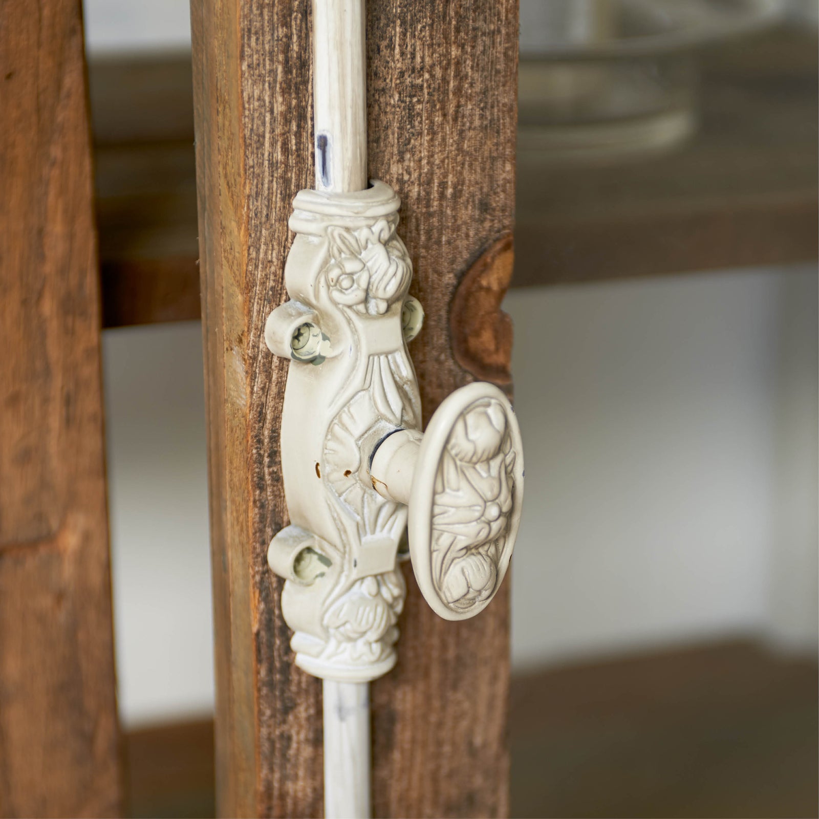 Detailansicht des Griffs des Glasvitrinenschranks mit kunstvoller Verzierung, zeigt die hochwertige Handarbeit und elegante Gestaltung