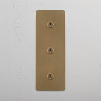 Corston-Kipphebelschalter 3x in vertikalem Dreifachrahmen – Antikes Messing