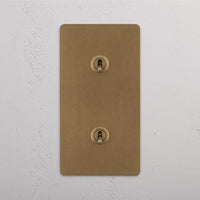 Corston-Kipphebelschalter 2x in vertikalem Zweifachrahmen – Antikes Messing