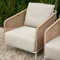 Wetterfester Outdoor-Loungesessel aus Rattan im Garten, ideal für entspannte Stunden im Freien.