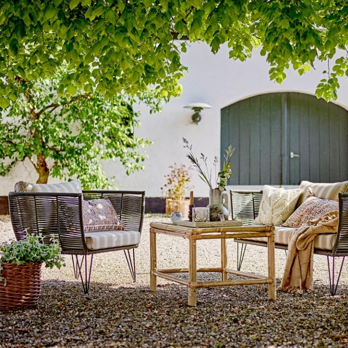  Outdoor Loungesessel aus schwarzem Metall im Garten mit passendem Outdoor-Sofa. Wetterfeste Gartenmöbel für stilvolle Entspannung im Freien.