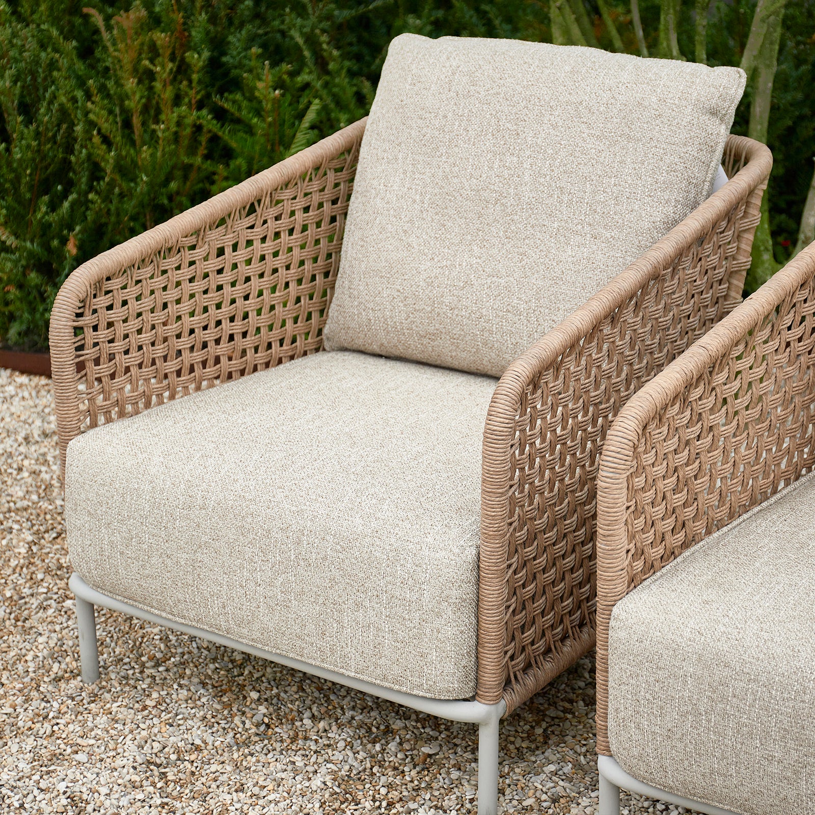 Wetterfester Outdoor-Loungesessel aus Rattan im Garten, ideal für entspannte Stunden im Freien.